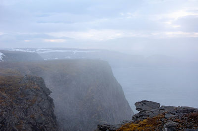 Scenic view of rocks in sea against sky