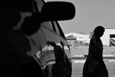 Side view of silhouette man in city against sky