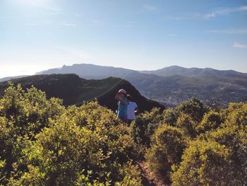 Man standing by plants against sky
