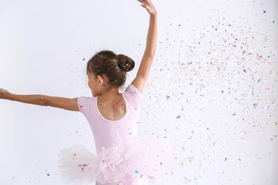 Full length of woman dancing against white wall