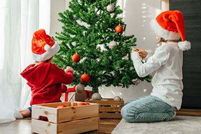 New year and merry christmas. children prepare for the holiday and decorate the christmas tree 