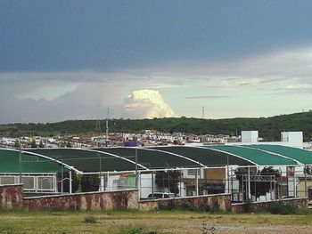 Built structure on landscape against cloudy sky