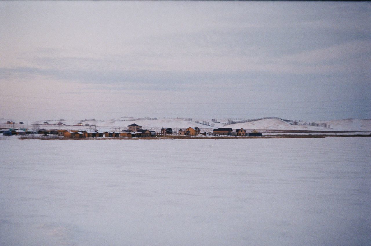 FROZEN LAKE AGAINST SKY DURING WINTER