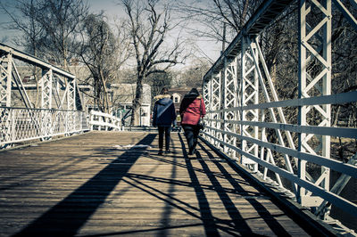 People walking on snow covered bare trees