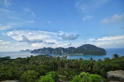 Scenic view of sea and mountains against blue sky