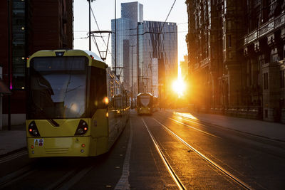 Uk, england, manchester, cable cars moving along downtown street at sunset