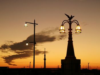 Silhouette of street light in city during sunset