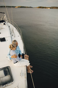 High angle view of senior couple admiring sea while sitting on boat