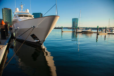 Sailboats moored at harbor