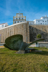 Old building by field against sky