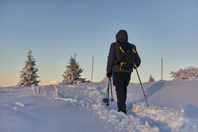 Rear view of man on snow field against sky