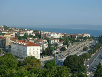 High angle view of buildings and sea against clear sky