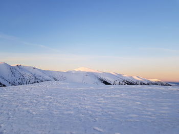 Scenic view of snow covered landscape against blue sky