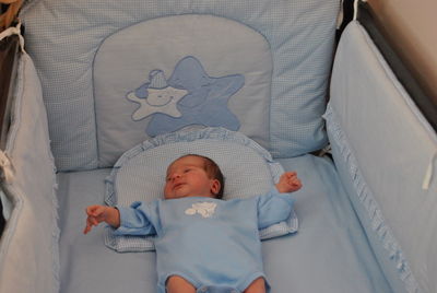 High angle view of child lying in crib