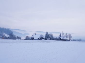 Scenic view of snow covered field against sky