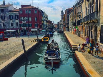 Boats in canal along buildings