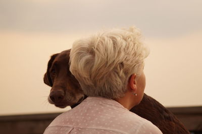 Close-up of woman embracing dog