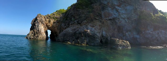 Rock formations by sea against sky