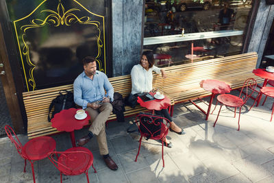 High angle view of business colleagues talking at sidewalk cafe