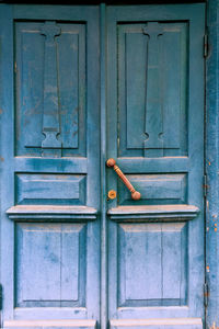 Old blue door with brass handle in abandoned ancient house. close-up. outdoors.