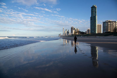 Woman on beach by sea against sky