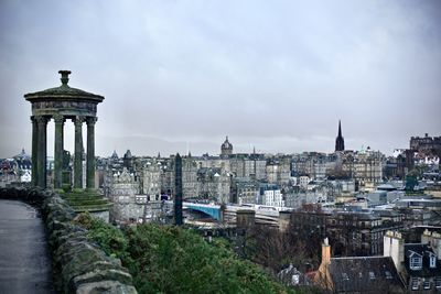 Buildings in city against cloudy sky