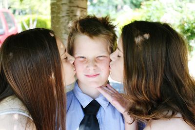 Sisters kissing brother