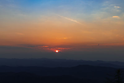 Scenic view of silhouette mountains against romantic sky at sunset