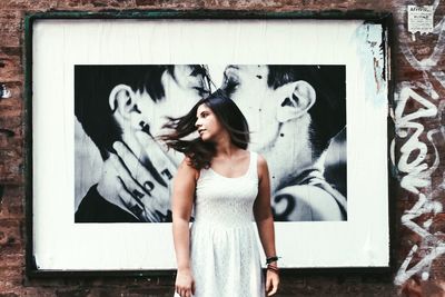 Portrait of woman standing against wall