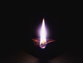 Close-up of lit candle in dark room