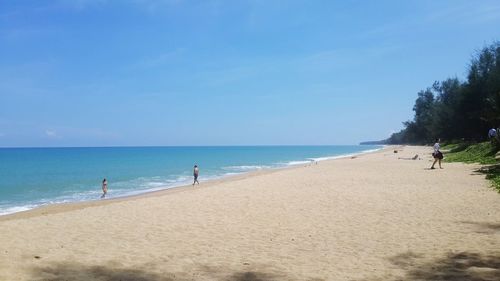 View of calm beach against blue sky