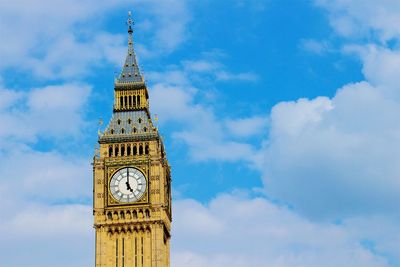 Low angle view of clock tower against cloudy sky