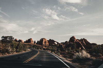 Road leading towards mountains against sky
