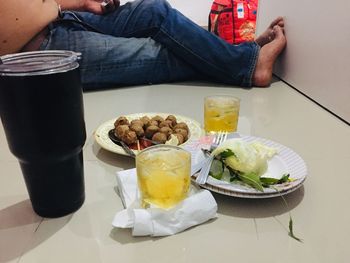 Low section of man sitting on table