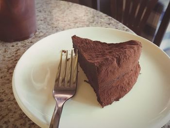 Close-up of chocolate cake and fork on plate at home