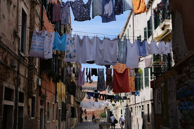 Low angle view of clothes drying amidst buildings