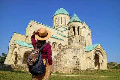 Female visitor being impressed by bagrati cathedral at ukimerioni hilltop, kutaisi, georgia