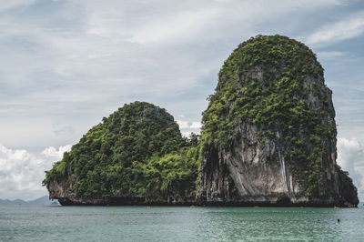 Rock formations by sea against sky