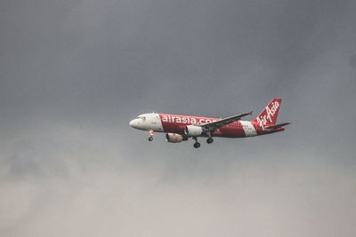 Low angle view of airplane flying against sky