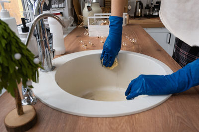 Cropped image of person washing hands in bathroom