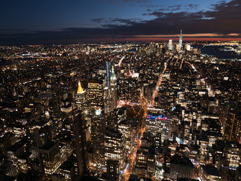 Aerial view of illuminated cityscape against sky at night