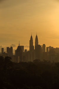 Buildings in city against sky during sunset