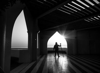 Silhouette man in illuminated corridor