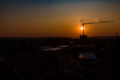 Silhouette buildings against sky during sunset