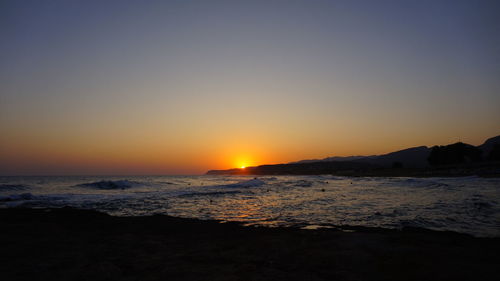 Scenic view of sea against clear sky during sunset