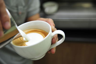 Close-up of hand holding coffee cup