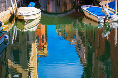 Sky and boats reflecting in the waters of the empty canals of venice