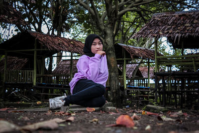 Portrait of woman sitting against plants