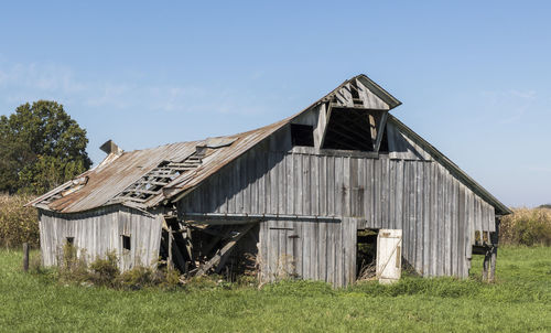 Abandoned house on field against sky