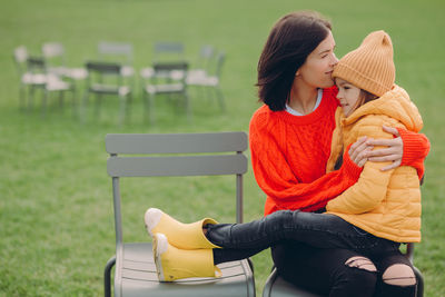 Mother and daughter sitting at park